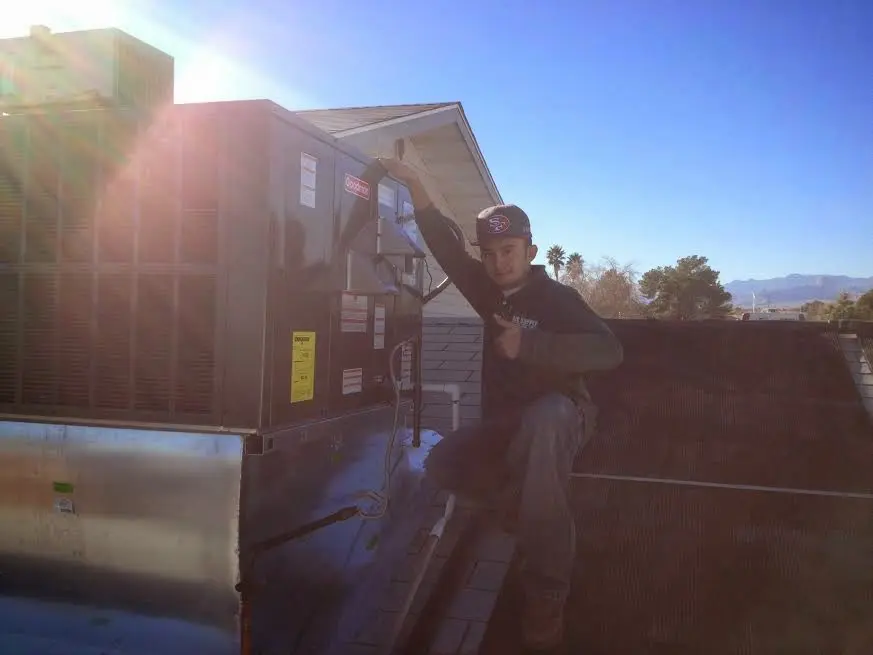 HVAC technician performing AC Tune-Up on a rooftop unit in Keystone